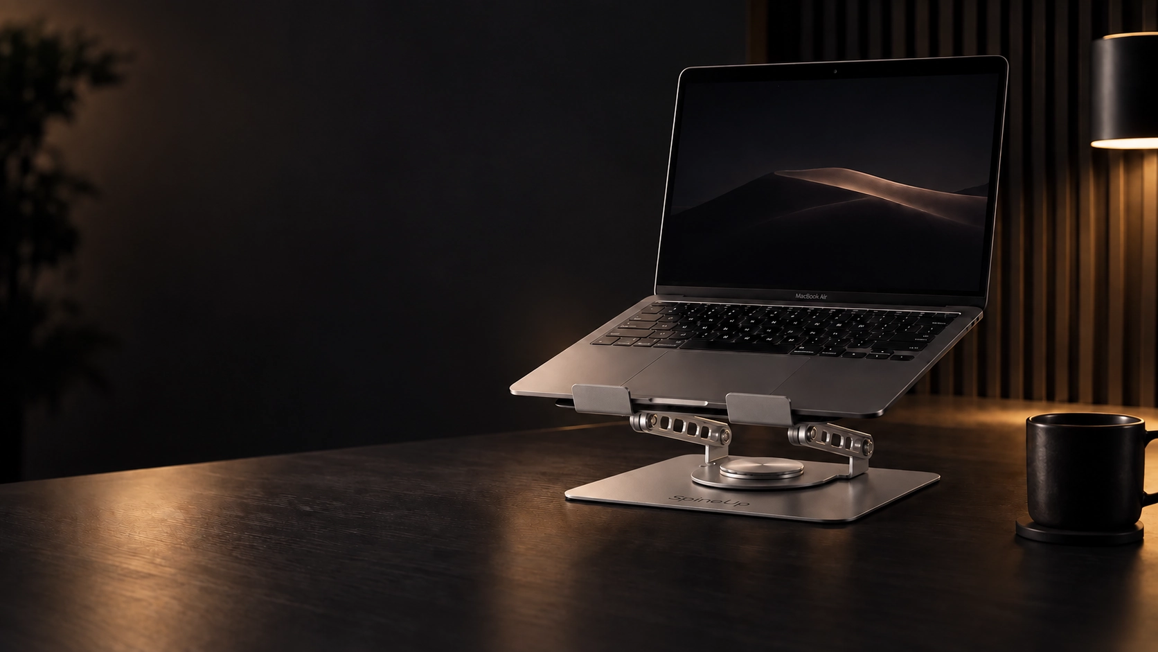 SpineUp Pro plateado elevando una notebook sobre un escritorio